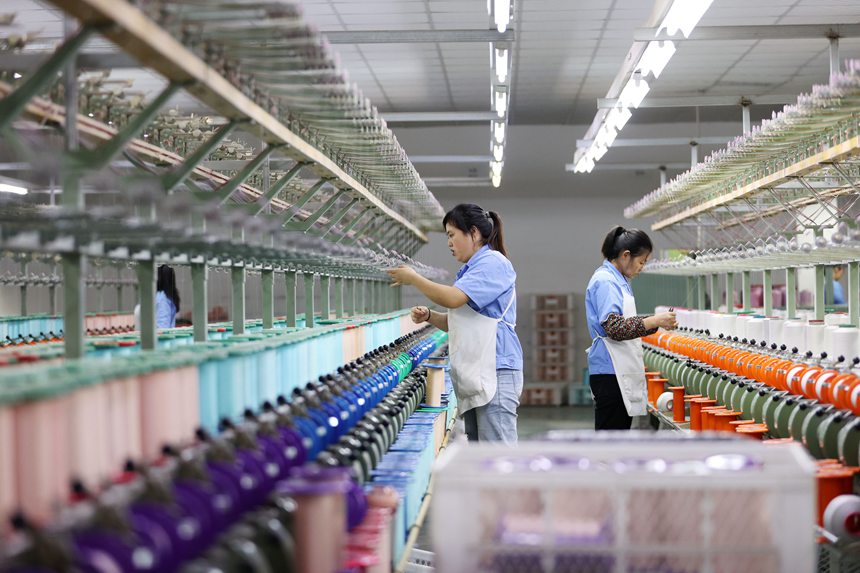 絲綢紡織女工在生產(chǎn)車間忙碌。楊敏攝